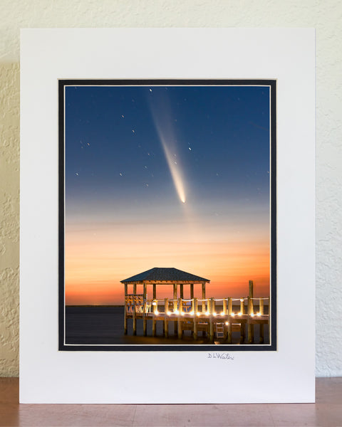 The comet known as C/2023 A3 Tsuchinshan-ATLAS, shines over Kitty Hawk Bay at twilight, captured from Kill Devil Hills beach boat ramp. The gazebo and dock in the foreground add a peaceful touch to this Outer Banks view.