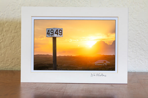 Backlit by the warm glow of the setting sun, the Ramp 49 sign stands against a backdrop of rolling dunes and golden light. A favorite fishing access on Hatteras Island, this spot is a go-to for locals and visitors drawn to the quiet beauty of the area.