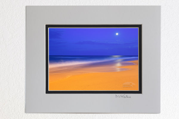 5 x 7 luster prints in a 8 x 10 ivory and black double mat of These colors are pretty much how I saw  them.  The yellow on the beach is from an incandescent spotlight shining from Kitty Hawk pier. The blue in the sky is the natural twilight color. I had to use a long exposure to gather enough light. The waves became very soft as they moved during the exposure.