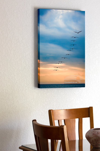 20"x30" x1.5" stretched canvas print hanging in the dining room of 12 brown pelicans flying out to sea on a stormy morning on the Outer Banks of NC.
