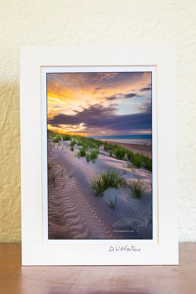4 x 6  Luster print in a 5 x 7 ivory mat of Break of Day Sunrise over the dunes at Frisco beach Cape Hatteras National Seashore on the Outer Banks of North Carolina. Because of the way Cape Point is positioned, Frisco Beach is the only place that I know of on Outer Banks that the sun rises along the beach.