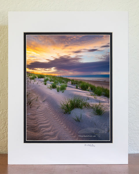 8 x 10 in a 11 x 14 ivory and black double mat of Break of Day Sunrise over the dunes at Frisco beach Cape Hatteras National Seashore on the Outer Banks of North Carolina. Because of the way Cape Point is positioned, Frisco Beach is the only place that I know of on Outer Banks that the sun rises along the beach.