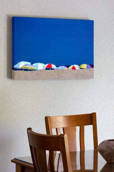 20"x30" x1.5" stretched canvas print hanging in the dining room of Beach umbrellas lined up on a summer beach day in Kitty Hawk North Carolina.