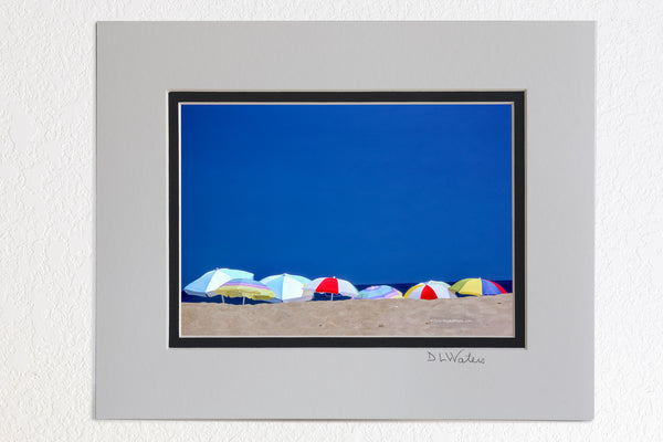 5 x 7 luster prints in a 8 x 10 ivory and black double mat of  Beach umbrellas lined up on a summer beach day in Kitty Hawk North Carolina.