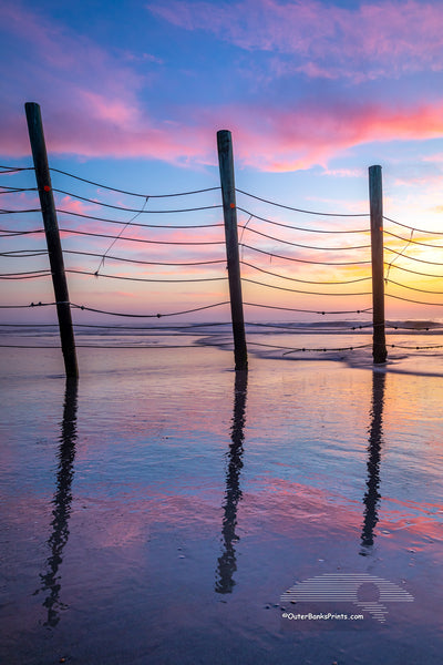 Fence reflection at sunrise that keeps the wild horses north of Corolla on the Outer Banks of North Carolina.