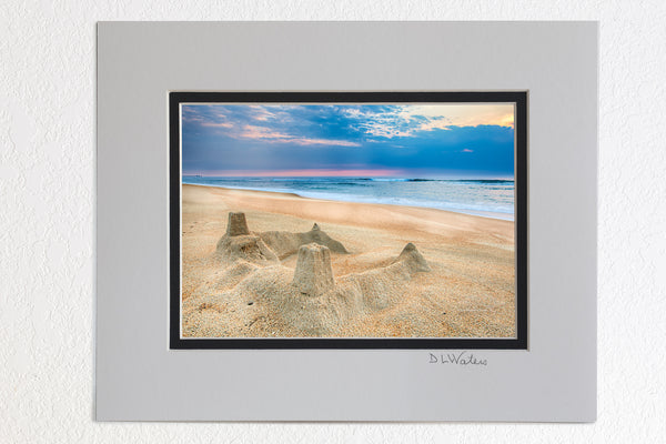 5 x 7 luster prints in a 8 x 10 ivory and black double mat of  The sun rising behind a sandcastle on the beach at Kill Devil Hills on the Outer Banks of North Carolina.