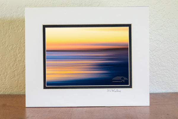 Intentional camera movement to create long streaks of light at sunset along Frisco beach in Cape Hatteras National Seashore, NC.