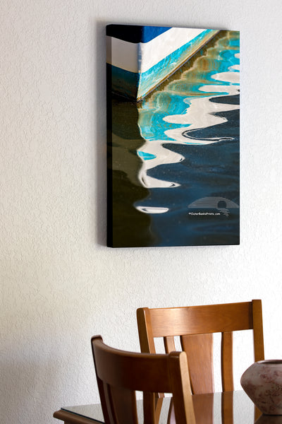 Pattern of light, shadow, and color in the reflection of the bow of a fishing boat in Wancheese Harbor on the Outer Banks of NC.