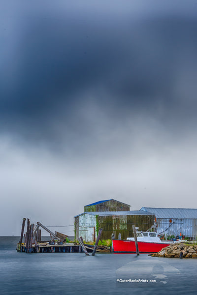 Red boat with a approaching storm at Wanchese Harbor Outer Banks NC.