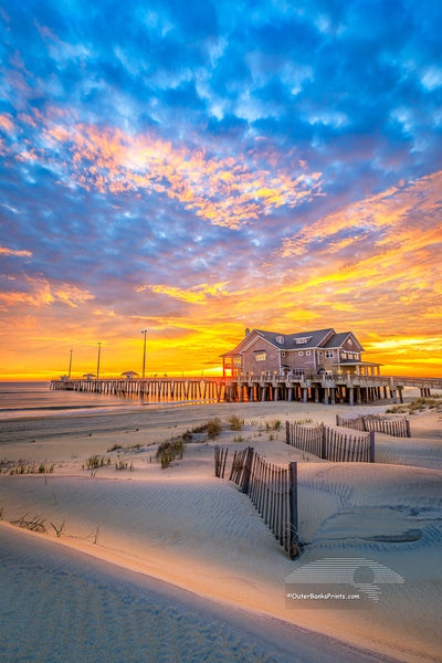 Sand dunes and sand fence at sunrise at Jennette's Pier in Nags Head on the Outer Banks of NC.