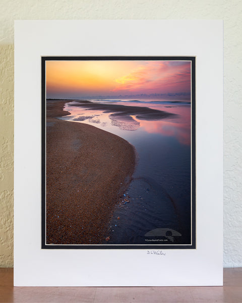 Empty beach with tide pools at sunrise on Frisco Beach. Cape Hatteras Outer Banks of North Carolina.