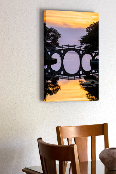 20"x30" x1.5" stretched canvas print hanging in the dining room of A still sunset reflection of the wooden bridge between the Whale Head Club and Currituck Beach Lighthouse in Corolla on the Outer Banks of NC.