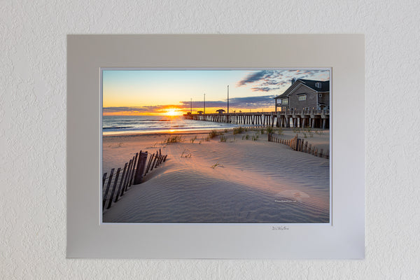 13 x 19 luster print in 18 x 24 ivory mat of Early morning light stretches across the dunes at Jennette's Pier in Nags Head on the Outer Banks of North Carolina.