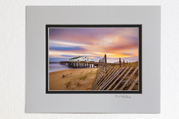 5 x 7 luster prints in a 8 x 10 ivory and black double mat of  Long exposure of sand fence, sunrise, clouds, and Kitty Hawk Fishing Pier on the Outer Banks of NC.