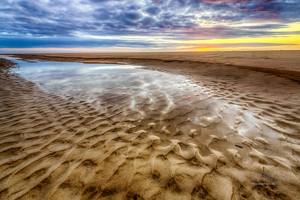 Sunrise reflection in a tide pool on a Corolla beach at Outer Banks, NC.