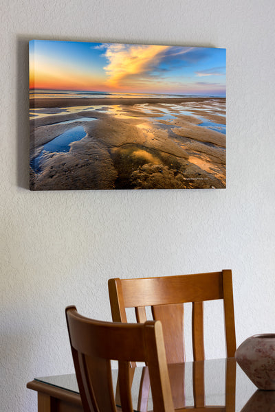 Tide pools reflecting sunrise at the beach in Corolla on the Outer Banks.