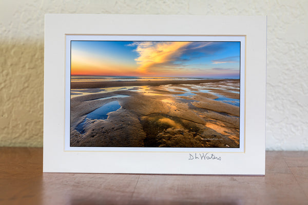 Tide pools reflecting sunrise at the beach in Corolla on the Outer Banks.
