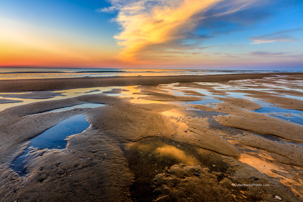 Tide pools reflecting sunrise at the beach in Corolla on the Outer Banks.