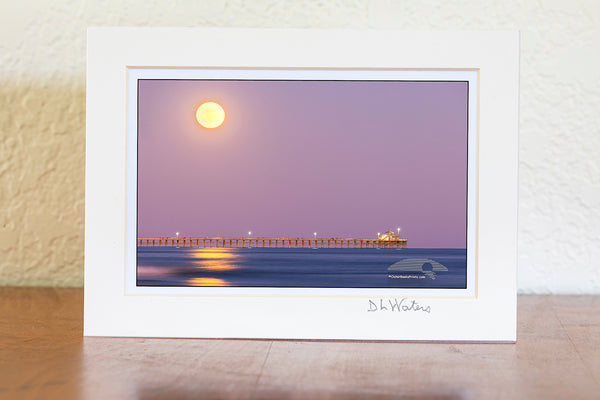 Hunters moon rising over Cherry Grove pier in North Myrtle Beach, South Carolina