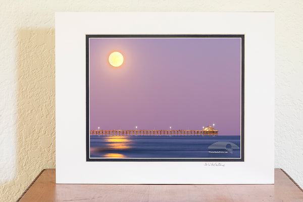 Hunters moon rising over Cherry Grove pier in North Myrtle Beach, South Carolina