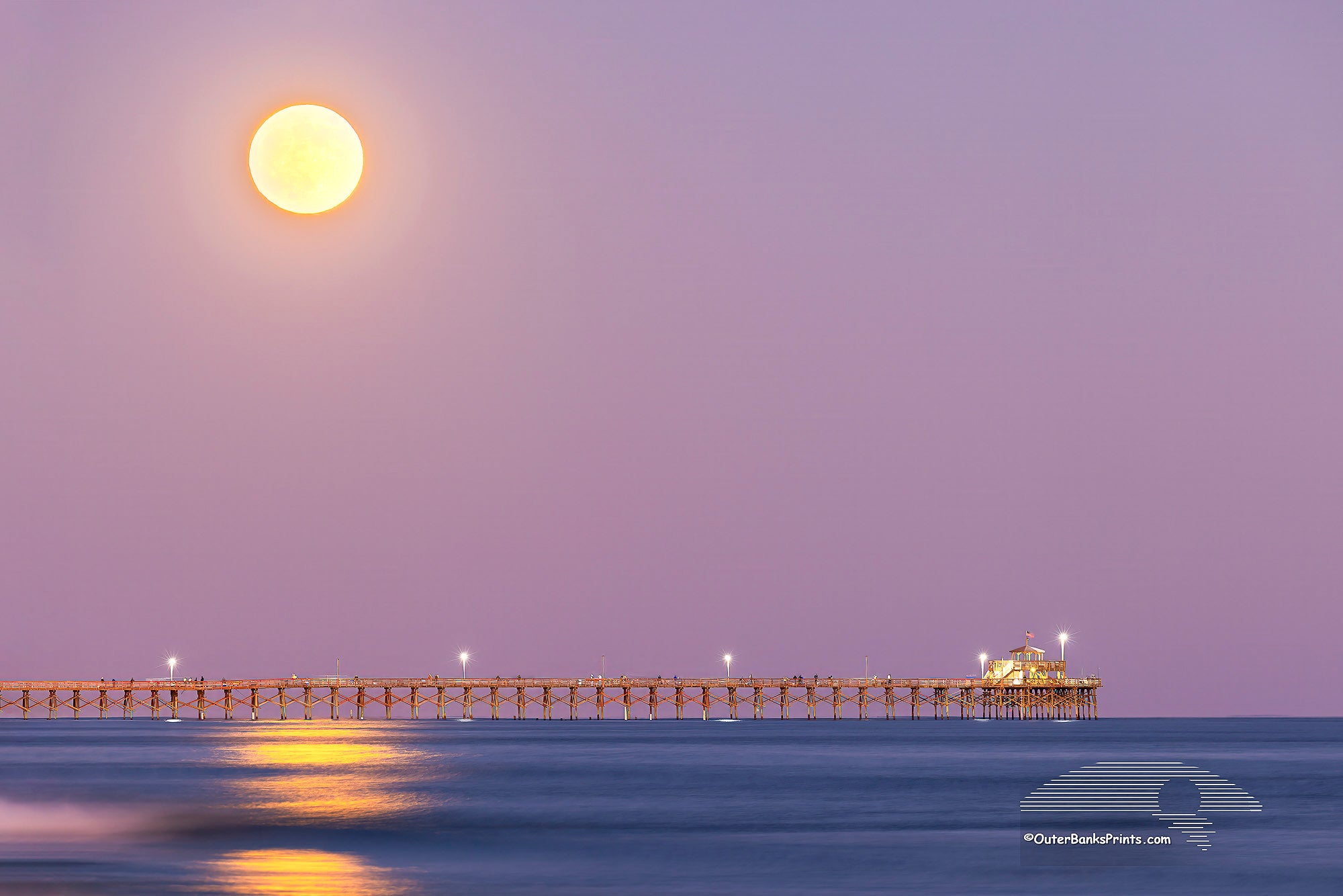 Hunters moon rising over Cherry Grove pier in North Myrtle Beach, South Carolina