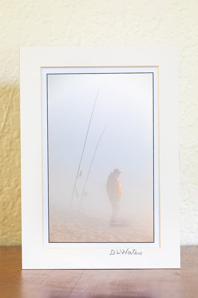 Fisherman hoping to catch some fish on this foggy winter morning at Cape Hatteras National Seashore  at the beach in Buxton North Carolina.