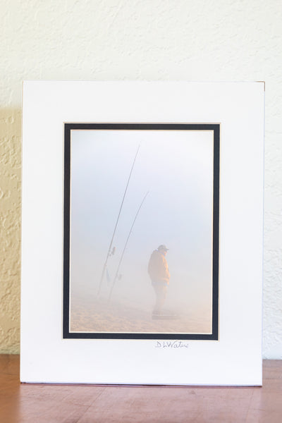 Fisherman hoping to catch some fish on this foggy winter morning at Cape Hatteras National Seashore  at the beach in Buxton North Carolina.