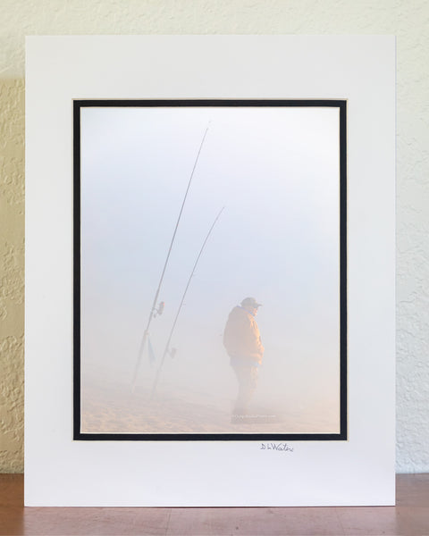 Fisherman hoping to catch some fish on this foggy winter morning at Cape Hatteras National Seashore  at the beach in Buxton North Carolina.