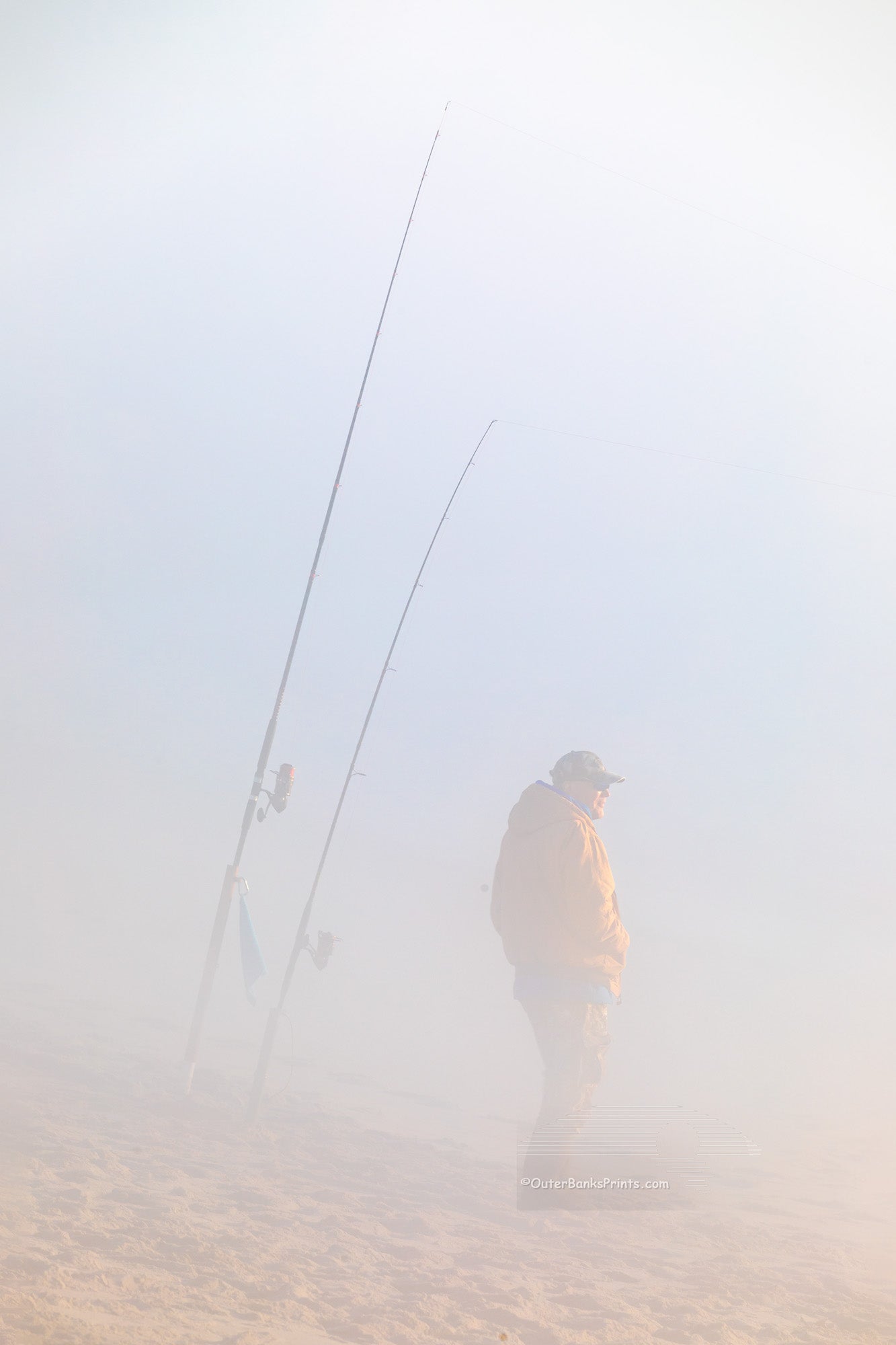 Fisherman hoping to catch some fish on this foggy winter morning at Cape Hatteras National Seashore  at the beach in Buxton North Carolina.