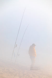 Fisherman hoping to catch some fish on this foggy winter morning at Cape Hatteras National Seashore  at the beach in Buxton North Carolina.