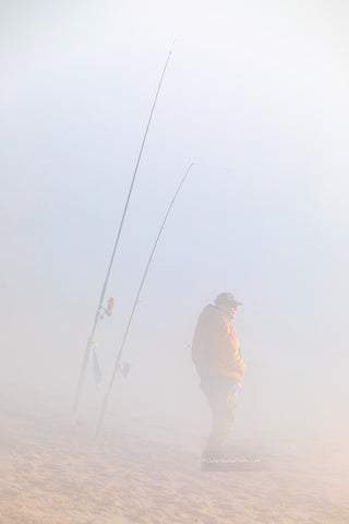 Fisherman hoping to catch some fish on this foggy winter morning at Cape Hatteras National Seashore  at the beach in Buxton North Carolina.