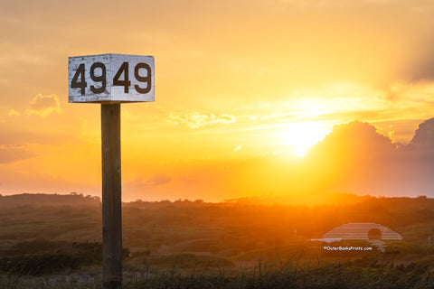 Backlit by the warm glow of the setting sun, the Ramp 49 sign stands against a backdrop of rolling dunes and golden light. A favorite fishing access on Hatteras Island, this spot is a go-to for locals and visitors drawn to the quiet beauty of the area.
