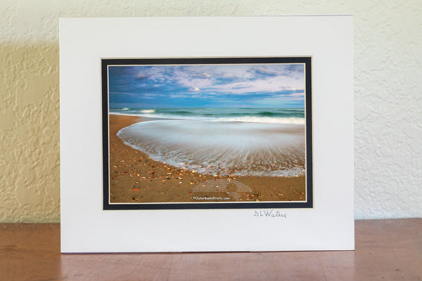 A slow shutter speed reveals the contrast between the recently deposited sharp shell shards and the receding wave at Frisco, North Carolina in Cape Hatteras National Seashore on the Outer Banks.