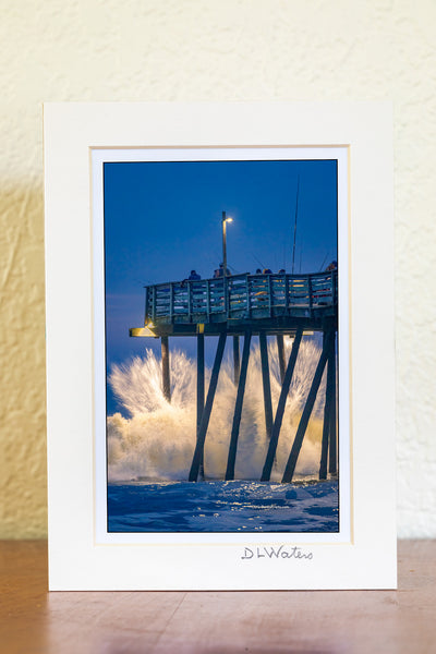 Just before Dawn large waves crash into Avalon fishing pier on the Outer Banks of North Carolina.