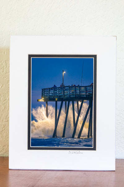 Just before Dawn large waves crash into Avalon fishing pier on the Outer Banks of North Carolina.