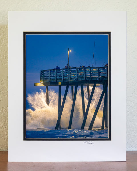 Just before Dawn large waves crash into Avalon fishing pier on the Outer Banks of North Carolina.