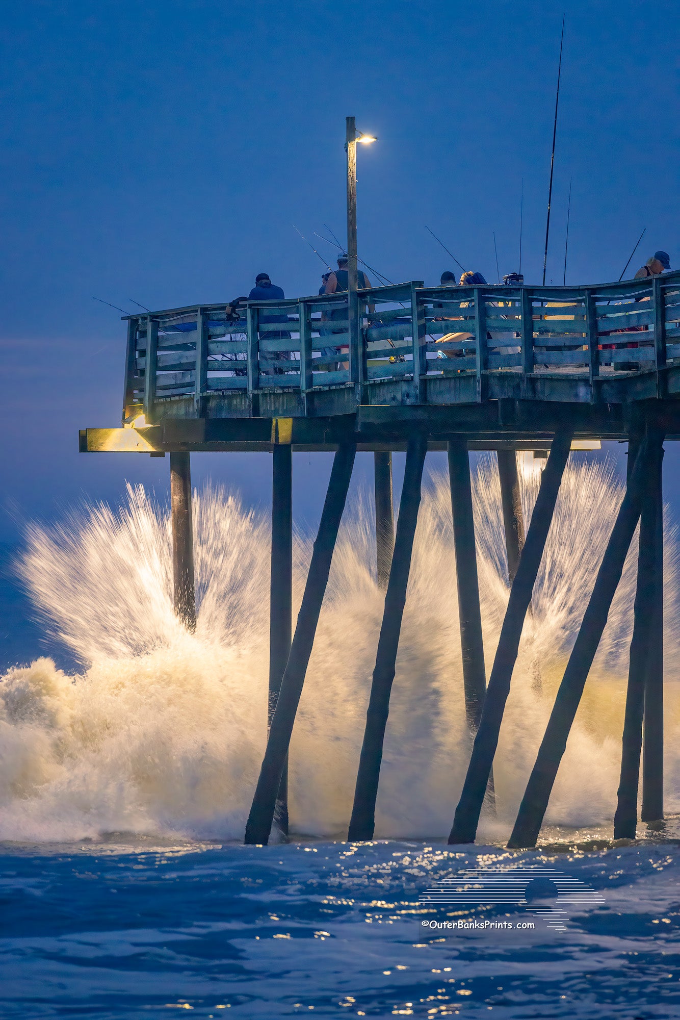 Just before Dawn large waves crash into Avalon fishing pier on the Outer Banks of North Carolina.