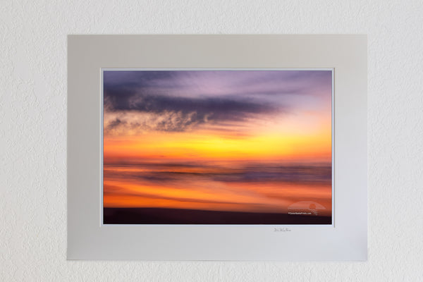 13 x 19 luster print in 18 x 24 ivory ￼￼mat of This sunrise beach impression was captured bouncing along wile driving on the beach using a 1/4 second shutter speed. in Corolla on the Outer Banks of North Carolina.