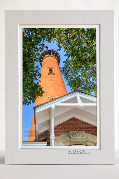 4 x 6 luster print in a 5 x 7 ivory mat of Currituck Beach Lighthouse framed by a tree.