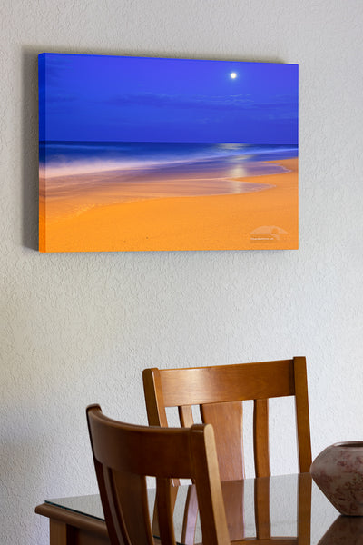 20"x30" x1.5" stretched canvas print hanging in the dining room of These colors are pretty much how I saw  them.  The yellow on the beach is from an incandescent spotlight shining from Kitty Hawk pier. The blue in the sky is the natural twilight color. I had to use a long exposure to gather enough light. The waves became very soft as they moved during the exposure.