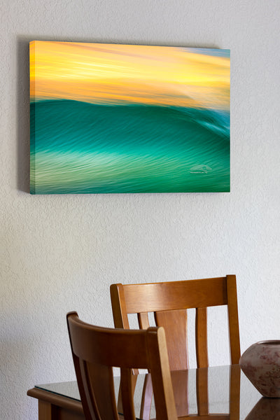 20"x30" x1.5" stretched canvas print hanging in the dining room of Impression of a wave at sunrise, using a long exposure to show movement on the outer Banks of NC.