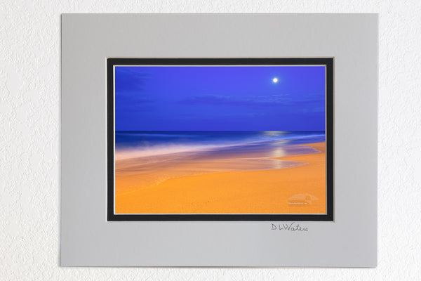  5 x 7 luster prints in a 8 x 10 ivory and black double mat of These colors are pretty much how I saw  them.  The yellow on the beach is from an incandescent spotlight shining from Kitty Hawk pier. The blue in the sky is the natural twilight color. I had to use a long exposure to gather enough light. The waves became very soft as they moved during the exposure.
