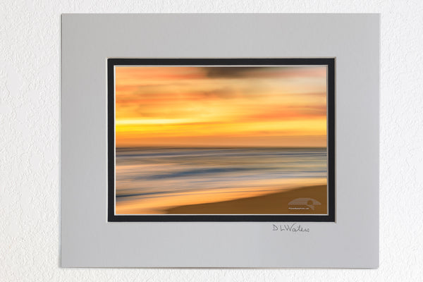  5 x 7 luster prints in a 8 x 10 ivory and black double mat of Soft gold sunrise Beach photo was created by using a long shutter speed and moving the camera a Kill Devil Hills beach on the outer banks of NC.