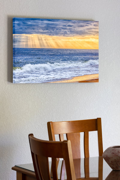 20"x30" x1.5" stretched canvas print hanging in the dining room of Sun rays breaking through a stormy sky over the beach on the Outer Banks.