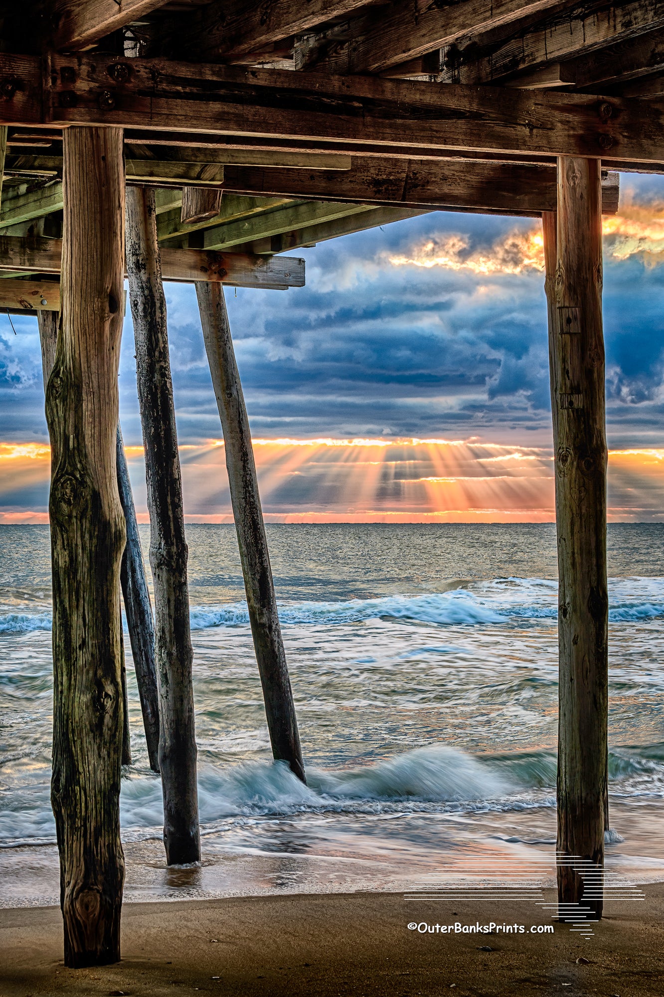 Rays of sun light streak through the clouds at Avalon Fishing Pier in Kill Devil Hills on the Outer Banks.