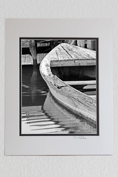 8 x 10 luster print in a 11 x 14 ivory and black double mat of Old boat and dock at hog quarter along Currituck sound. Photographed in black and white.