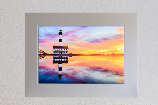 13 x 19 luster print in 18 x 24 ivory ￼￼mat of Reflection of sunrise and Bodie Island Lighthouse after a hard rain.