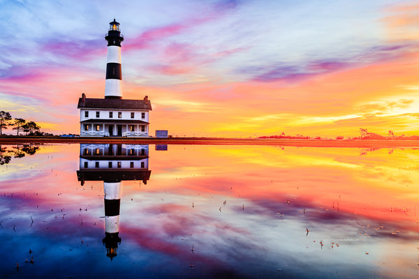 Reflection of sunrise and Bodie Island Lighthouse after a hard rain.