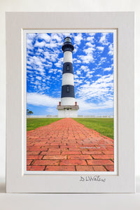4 x 6 luster print in a 5 x 7 ivory mat of Bodie Island Lighthouse red brick walkway leading up to the lighthouse and a blue sky with puffy white clouds.