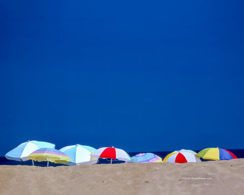 Beach umbrellas lined up on a summer beach day in Kitty Hawk North Carolina.